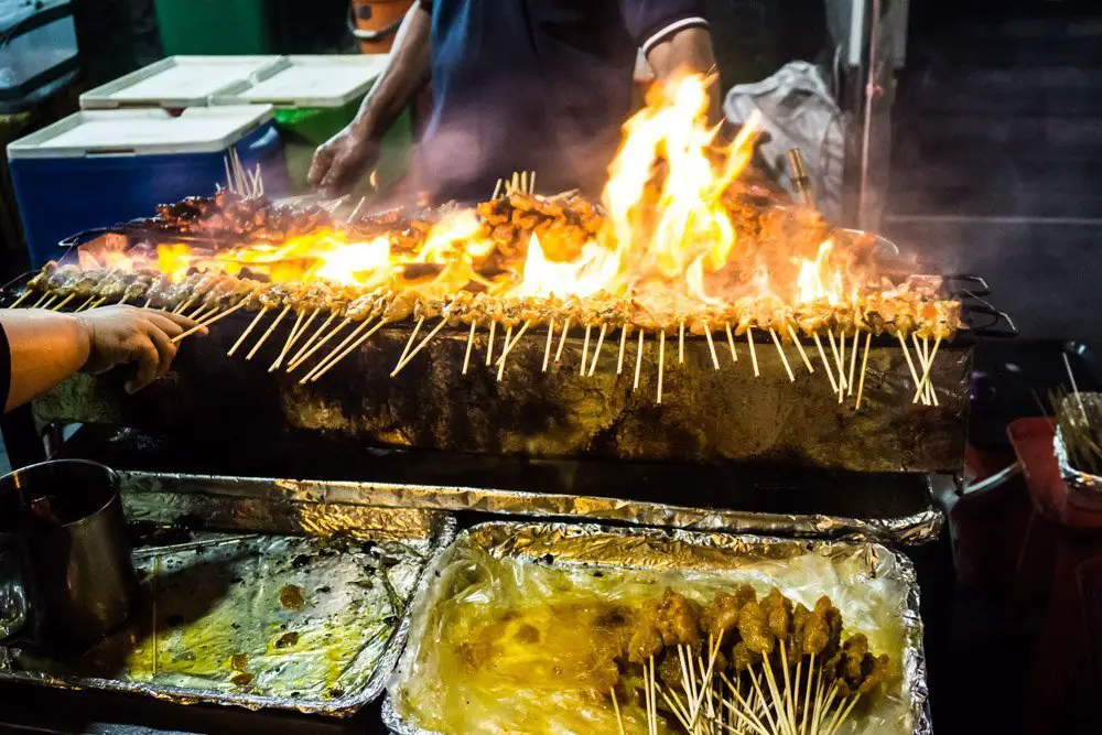 Satays: Skewers of meat cooked Malay style with Tumeric over an open grill. Stalls are not restricted to any race, and can be operated by Chinese, Malay, or Indian merchants. Typical meats are chicken, beef, prawns, and lamb (pork with the Chinese operators only). Delicious and cheap. 
